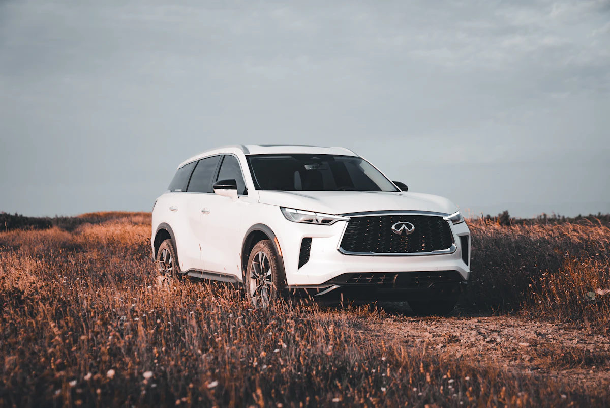 Infiniti QX80 branco visto de frente em campo aberto